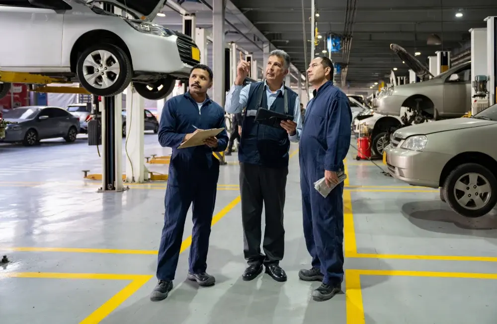 FEATURED_CASE_STUDY_Service_Department_Image_3_men_in_jumpsuits_looking_at_a_car