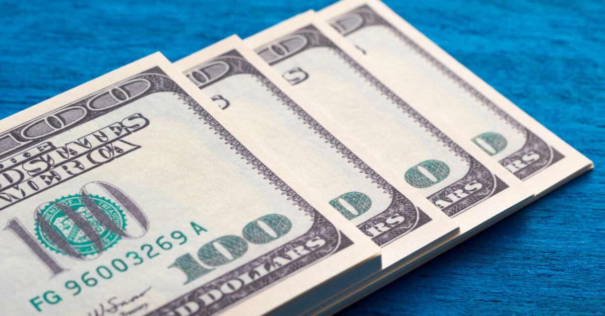 a-stack-of-american-hundred-dollar-bills-lies-on-a-blue-background-in-close-up.jpg