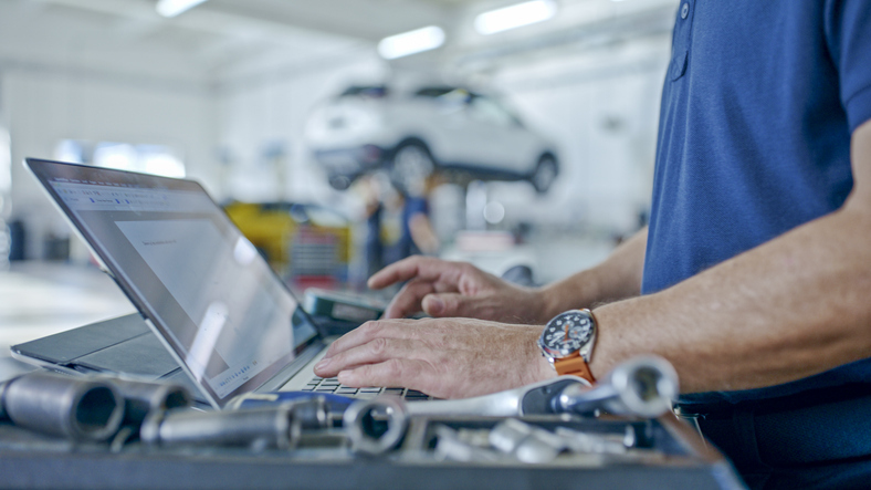 EHS-Man-typing-car-on-lift