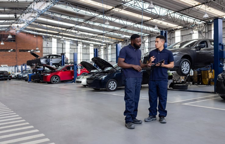 EHS-mechanics-talking-in-shop-gettyimages-2214445664