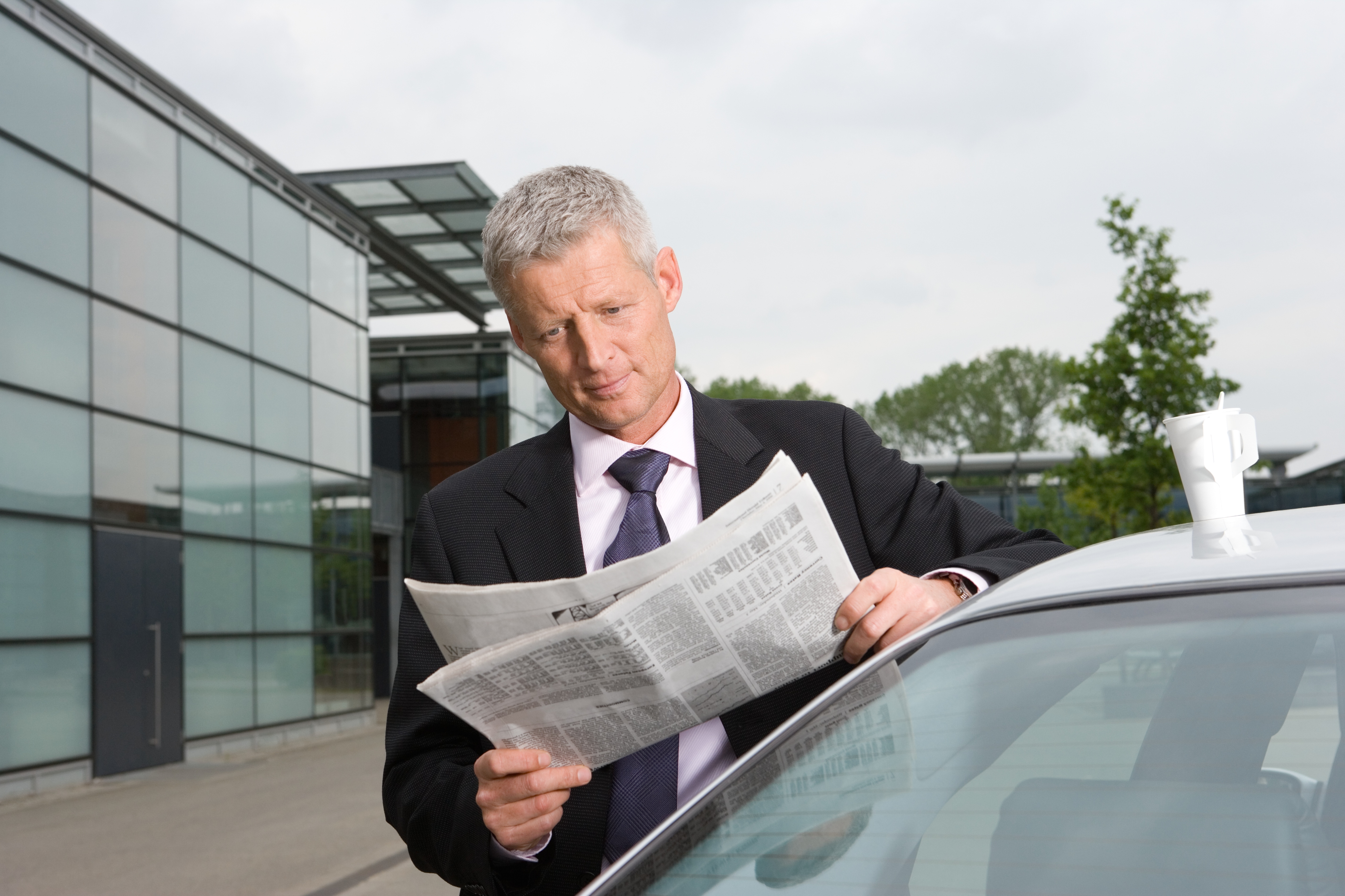 Man-reading-newspaper-by-car-GettyImages-71919115